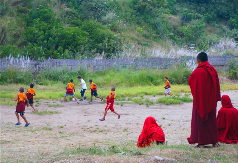 Kids have fun playing football in a simple "football field" in Bhutan.