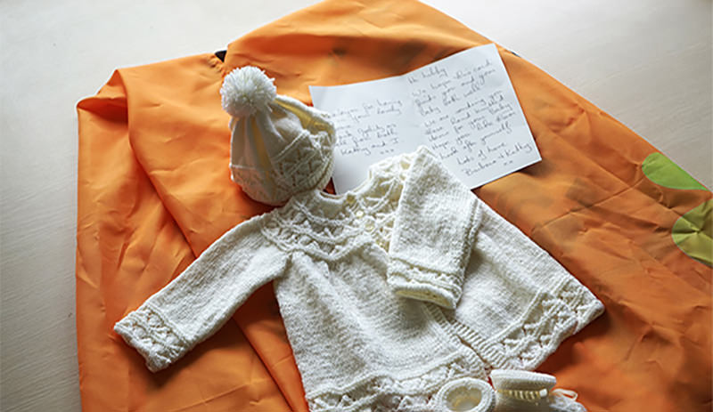 An knitted baby outfit given by our clients Barbara and Kathy to their travel consultant Libby
