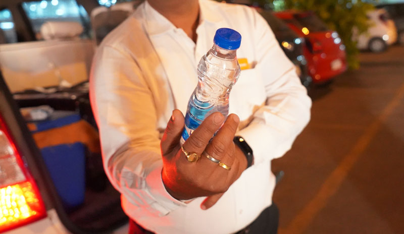 Passer une bouteille d'eau avec la main droite