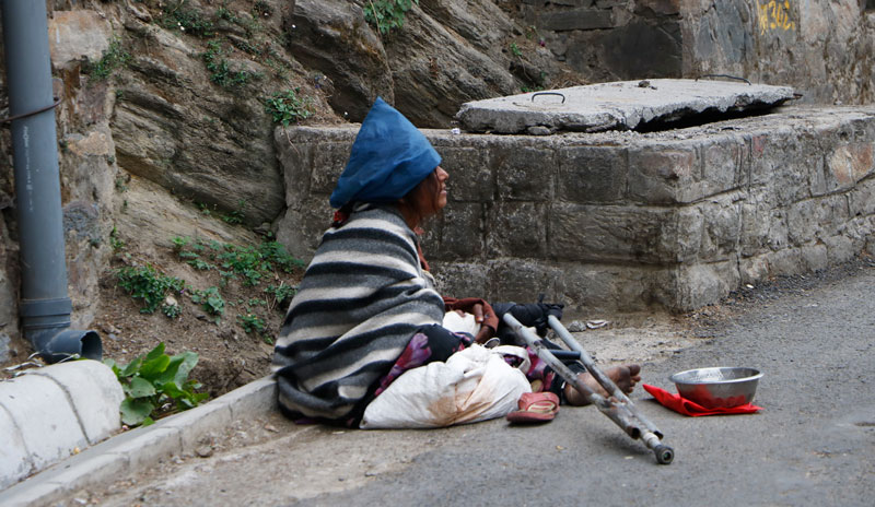Un mendiant est assis dans la rue