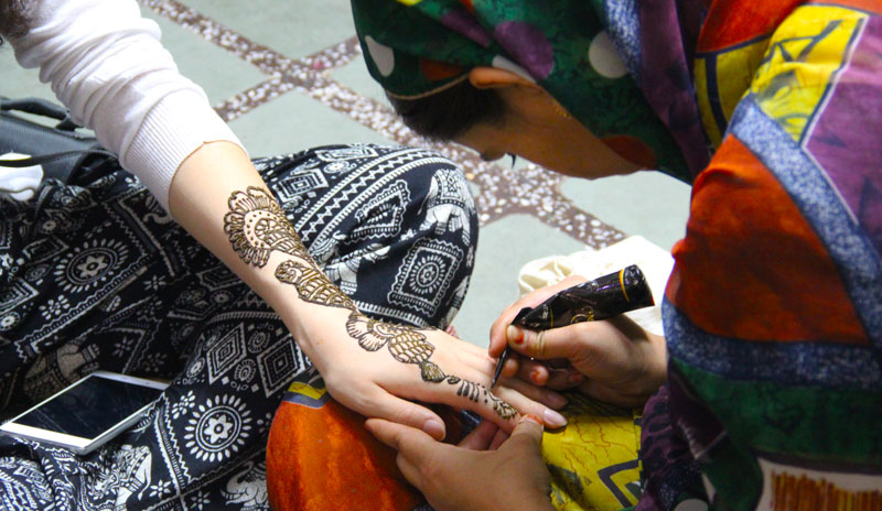 Un peintre est en train de faire le mehndī