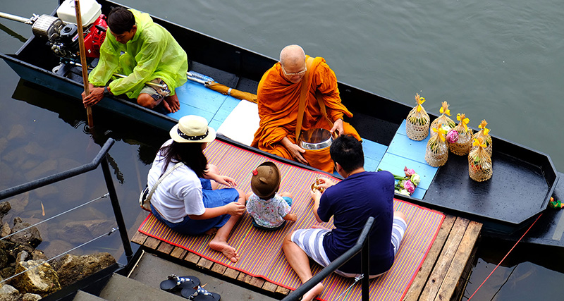 Thai People Making Merit to a Monk
