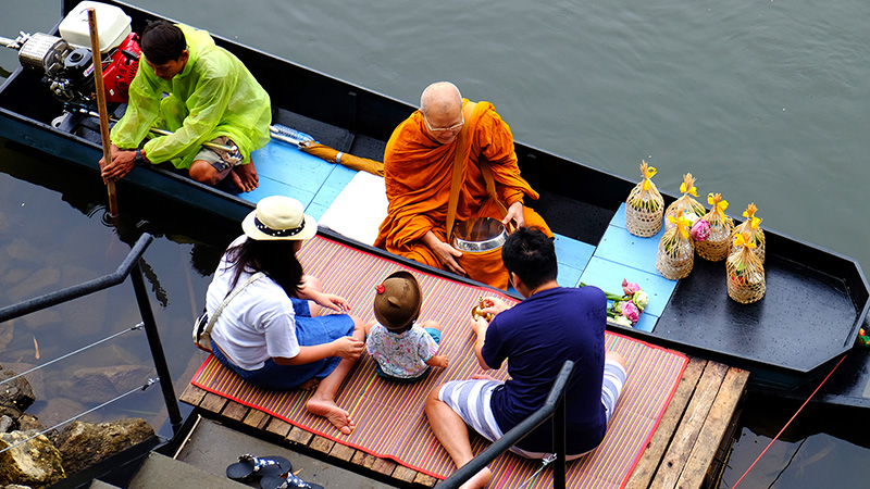 Thai Family Making Merit to a Monk