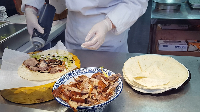 The cook is making a roast duck pancake