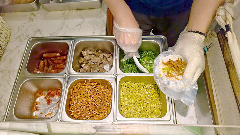 A staff is making a sticky rice wrap