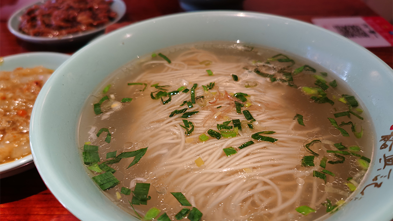 A bowl of noodles in clear broth