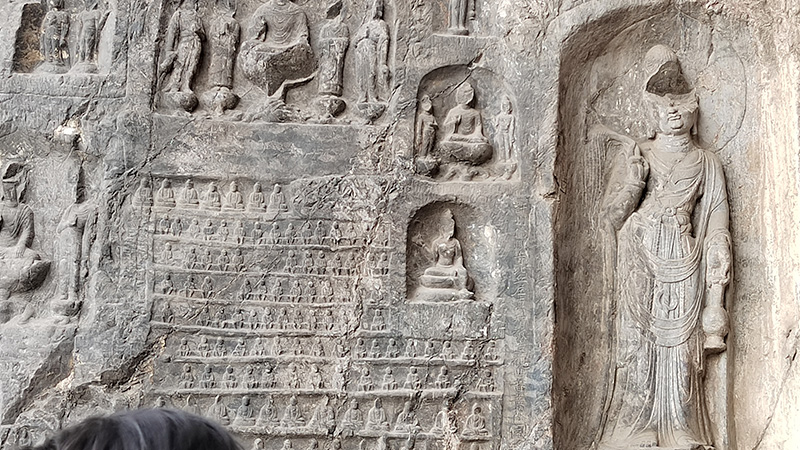 A wall of Buddha statues in the Wanfo Cave