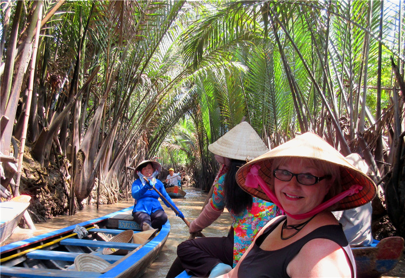Cruising along the canals of Mekong River by sampan in Vietnam