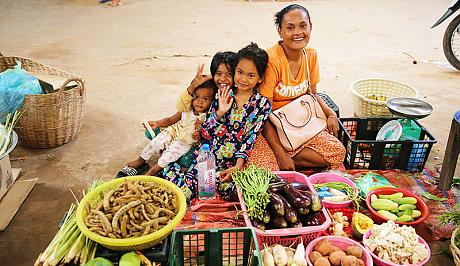 A happy family selling vegetables in a market in Siem Reap, Cambodia